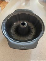 Dark grey metal 11-inch Bundt pan with fluted design and central tube.