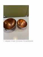 Photo showing two copper bowls, one larger (French Mauviel 10") and one smaller (Korean 8") on a white countertop, illustrating their size and condition.
