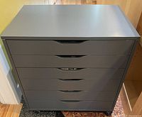 Front view of grey Ikea Alex drawer unit showing 6 drawers and casters.
