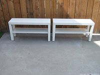Two white IKEA LACK TV stands side by side on concrete background, front view