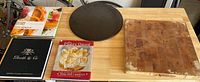 Overview of main cutting board, pizza stone, and three cookbooks.
