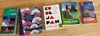 Six travel related books laid side by side showing front covers and spines. Titles include Japan, Tokyo Precinct, Colombia, Thailand, and Istanbul.