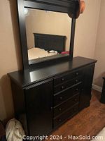 Full view of wooden dresser with five drawers and attached rectangular mirror