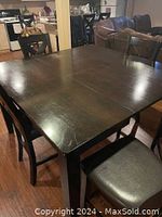 Photograph of rectangular counter height dining table in dark espresso finish showing minor surface scratches on top