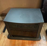 Black glass-door cabinet with metal handles seen from front and top, showing condition