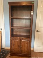 Front view of the laminate bookcase showing two adjustable shelves and lower cabinet with doors.
