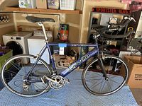 Full side view of the complete bicycle on a moving blanket in a garage