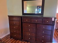 Full view of both dressers side by side with mirror hanging above larger dresser.
