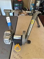 Full view of CycleOps indoor bike trainer showing metal frame, flywheel, and adjustment lever.