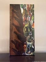Front view of the canvas art showing bottles and their shadows on wood surface