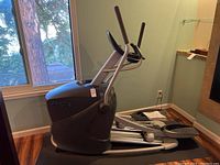 Full side view of the Octane Fitness Q35x elliptical machine situated near a window showing overall physical condition.