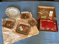 Arranged photo showing four Mexican pottery trays with colorful animal and floral painting, an oval china platter, and electric warmer with cord and box