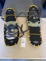 Pair of MSR Lightning Ascent snowshoes placed on a table, showing top view with bindings and yellow frames.