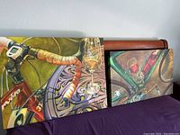 Two art prints featuring bicycles with wine glasses and decorative backgrounds, signed by Terri Hill.