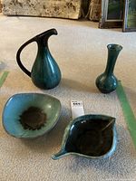 Four Blue Mountain Pottery pieces on carpet: vase, tall jug, bowl, and sauce boat.