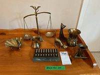 Lot showing all brass items including scales, cat figures, abacus, swan dish, vase with brass rope, and bullet vase.