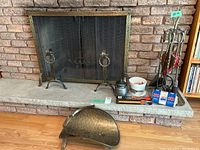 Overall fireplace setup with screen, andirons, brass log holder, utensil stand, kettle, bellows, and fire accessories