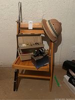 Fishing rod, tackle box with assorted tackle, Mitchell reel in box, Safari hat on wooden chair