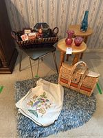 Full view of lot showing wooden stands, stool, basket with assorted items, woven bag, textile runner, and small rug