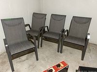 Four chairs arranged side by side against wall