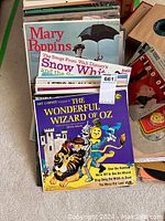 Stack of vintage children's and musical albums featuring Mary Poppins, Snow White, and The Wonderful Wizard of Oz in colorful covers.