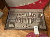 Full view of the flatware set in the canteen, showing the knives, forks, spoons, and serving utensils held in place with fabric loops.
