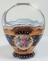 Front view of vintage Limoges ceramic basket showing blue, gold, and floral hand painting with silver handle
