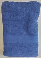Close up of folded blue cotton bath towel showing texture and decorative band.