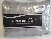 Packaged HYMOKEGE duvet cover set in clear plastic showcasing brand name and slogan.