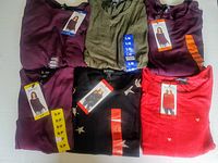 Top view of six Buffalo David Bitton long sleeve knit tops in various colors and sizes, all with tags.