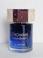 Front view of the blue gradient perfume bottle showing the silver cap and branded text on the bottle