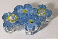 Top side view of the blue dogwood flower shaped glass candle holder showing two circular candle holders with yellowish-green rims