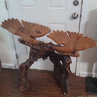 Front view of the vintage hand carved wooden eagle statue showing two eagles on a natural wood base with detailed wing and feather carving.
