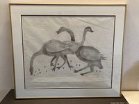 Front view of framed Inuit art print depicting three birds