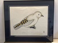 Framed print showing a stylized bird with white body, gold and black geometric pattern on wing