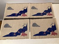 Four placemats laid out flat showing identical Inuit-themed designs with walrus, kayaks, igloos and clouds.