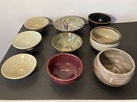 Top view of all nine bowls arranged in three rows showing different glazes and sizes.