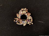 Front view of Sherman brooch showing multi-shaped rhinestones in a circular wreath pattern on black background.