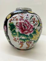 Side view of the ginger jar showing pink and yellow flowers with green leaves and a bird design.