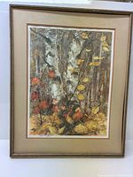 Framed color landscape print showing autumn leaves and tree trunks