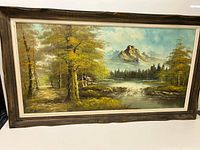 Full view of the framed oil landscape painting featuring mountains, trees, river, and cabin.