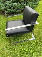 Side view showing chrome-plated steel frame and black upholstered seat and back