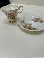 Teacup and saucer together showing floral pattern and gold trim