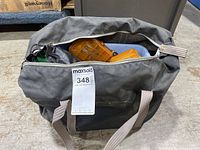 Front view of closed large grey fabric bag containing fishing gear