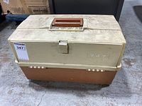 Closed view of Plano 747 fishing tackle box showing exterior condition with dirt and usage marks.