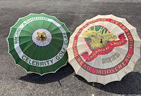 Photo of two vintage umbrellas laid on pavement showing full graphics and wooden handles, highlighting condition and design.