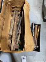 Box containing a variety of old wooden-handled mallets and hammers showing extensive wear and age.