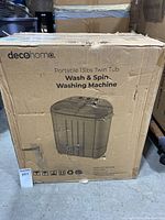 Damaged cardboard box of DecoHome Portable 13lbs Twin Tub Wash & Spin Washing Machine with visible product image and branding on the front.