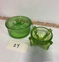 Photo showing both uranium glass pieces side by side with a ruler for scale, including the round powder dish with lid and the geometric ashtray.
