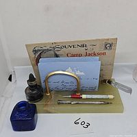 Front and angled view showing vintage marble mail holder with brass arch, ink bottles, pens, and letters.